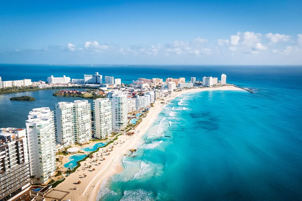 Aerial view of Cancún, Mexico, featuring stunning white sandy beaches, turquoise waters, and luxurious beachfront resorts.