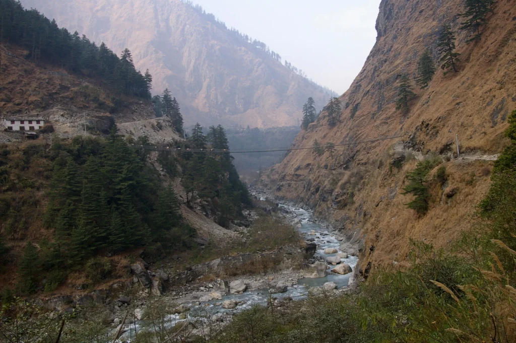 A breathtaking view of Kali Gandaki Gorge, Nepal, the world's deepest gorge, with a flowing river between towering mountains.