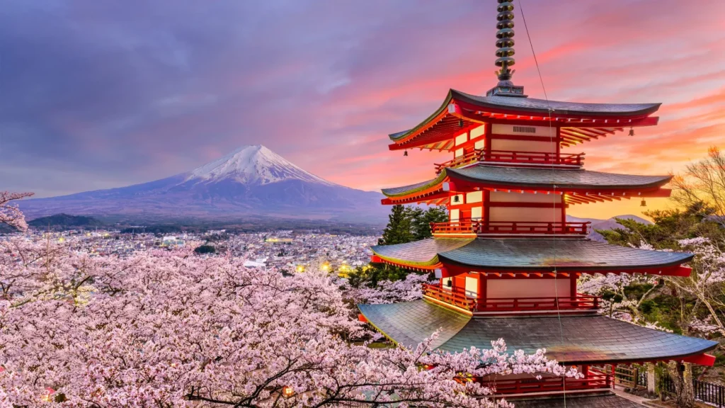 Breathtaking view of Mount Fuji, cherry blossoms, and Chureito Pagoda in Tokyo, Japan during sunset.